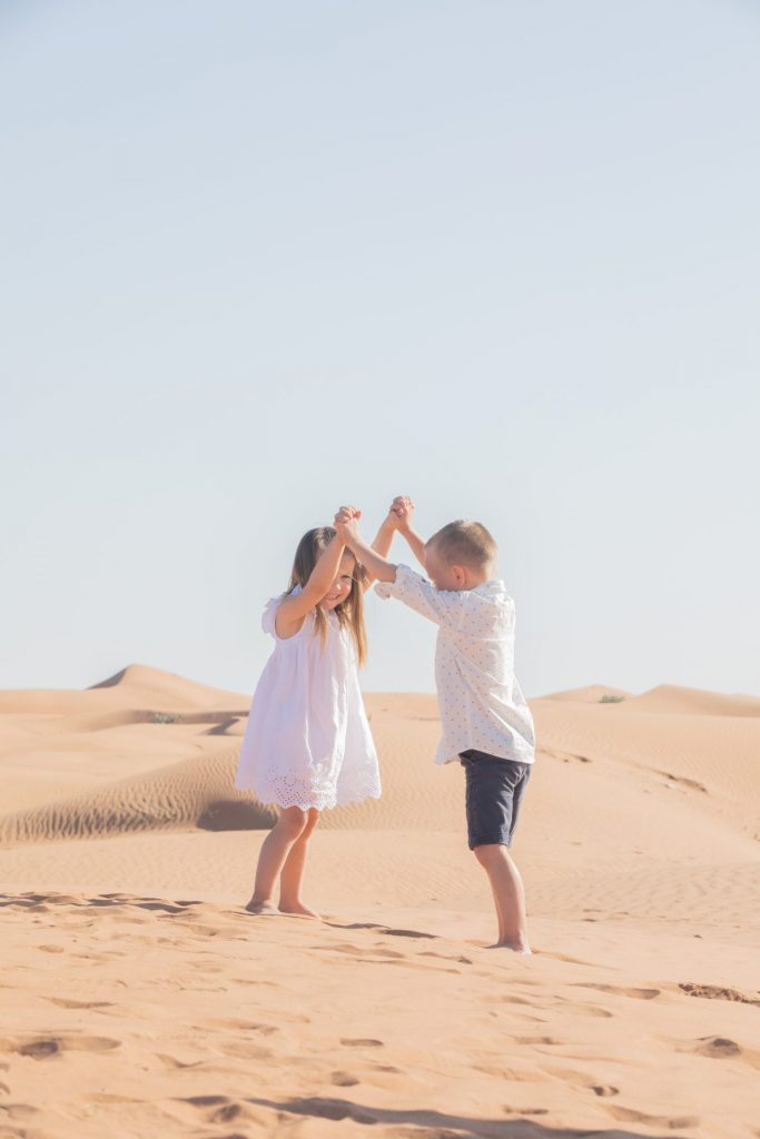 Family photographer in Dubai captures joyous moment of children playing in the desert